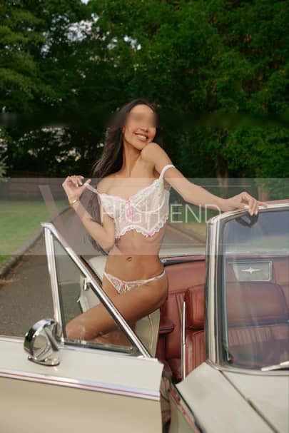 Tempting model Thalia is smiling while holding her bra strap