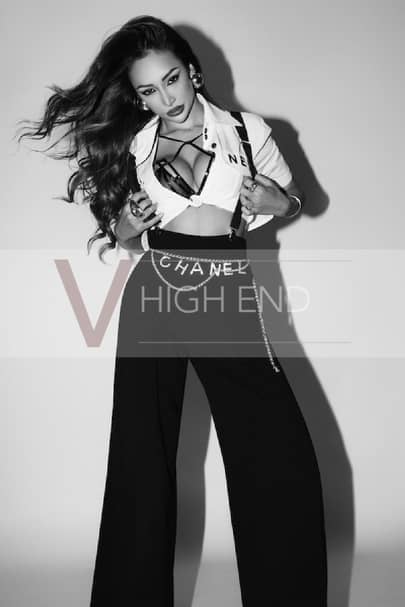 Black and white photo of escort Luna wearing smart black pants and white undone shirt
