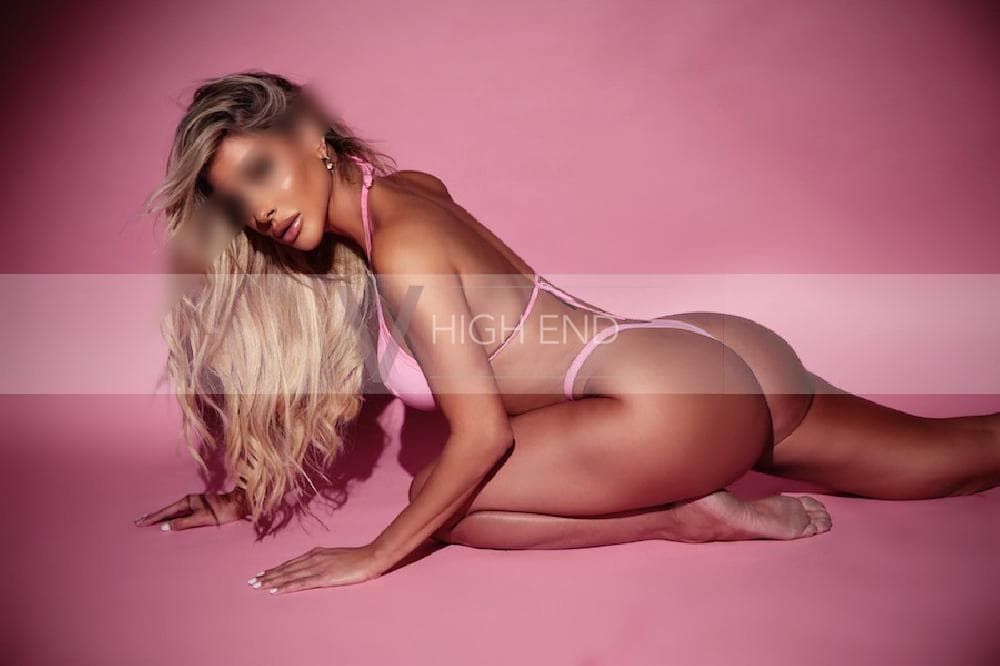 Seductive Antonella is kneeling on the floor in pink swimsuit displaying her perfect bottom