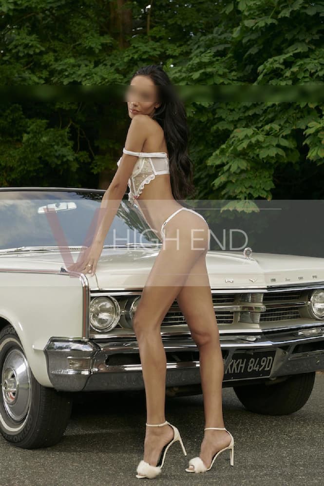 Professional model Thalia is showing her amazing tall body in front of the car