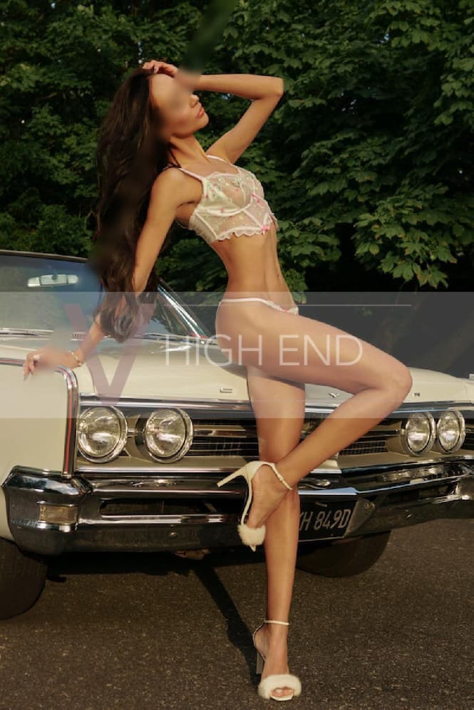 Thalia is posing for a picture wearing high heels sandals and sexy lingerie with white lingerie