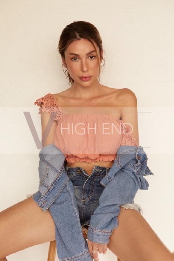 Barbara looks like girl next door posing on the chair in pink crop top, jeans shorts and a jacket
