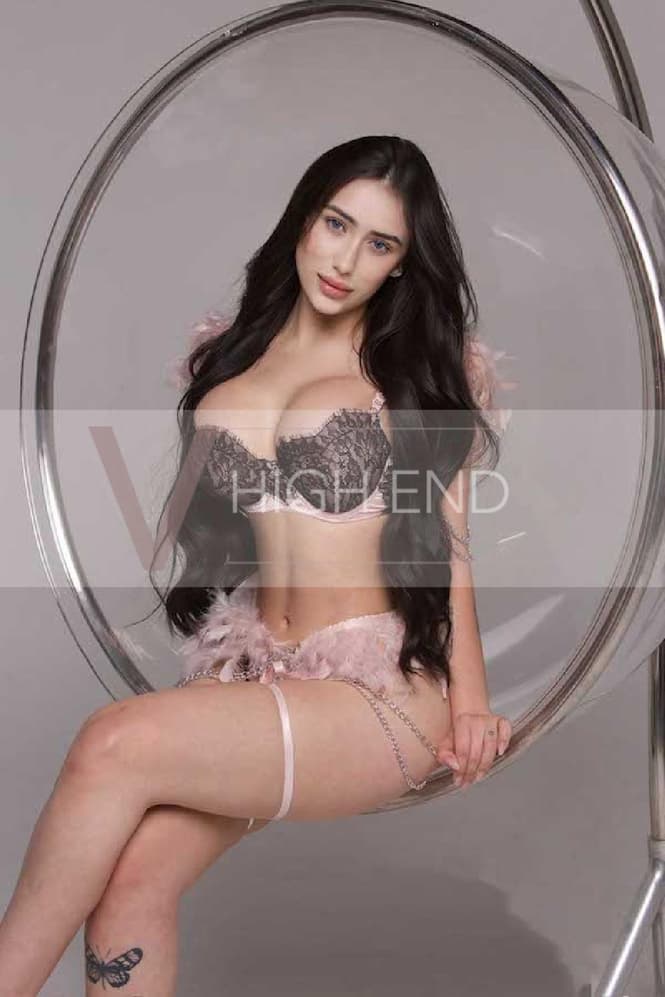 Elite escort Paulina is sitting in bubble hanging chair showing off her breast in seductive lingerie