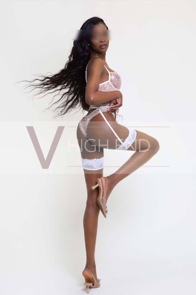 Full length photo of High End escort Melanie holding her panties upright and showing off bum