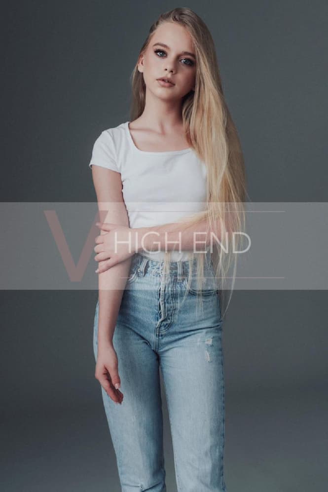Teen escort Liliana is posing in a jeans and white t-shirt