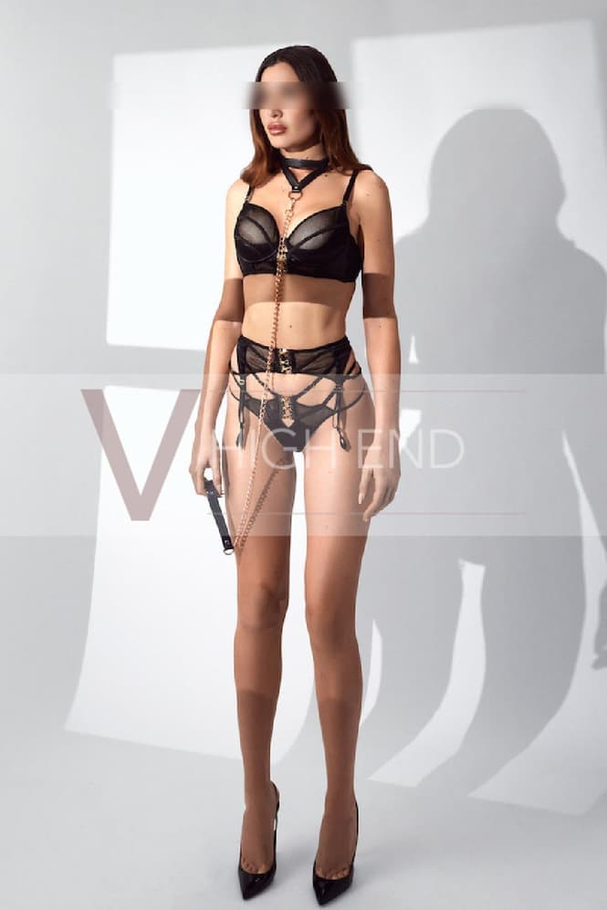 All natural escort Mary is wearing black racy lingerie with a suspender belt and chain necklace around her neck
