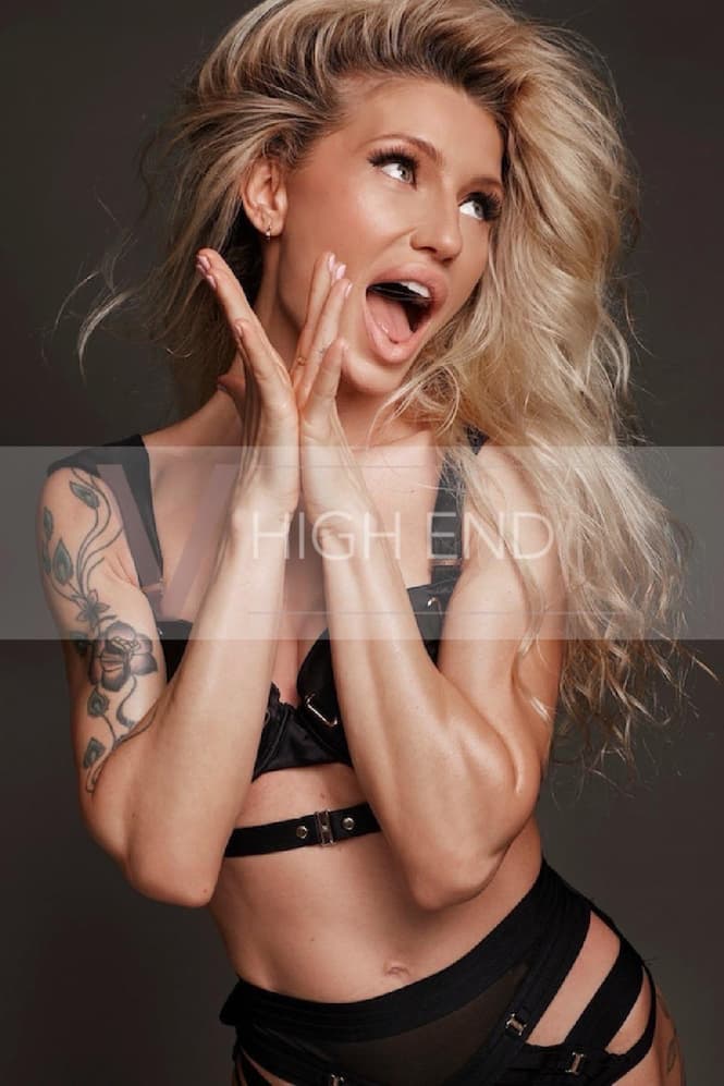 London escort Zeni is showing emotions on her face, clapping hands and posing in black underwear