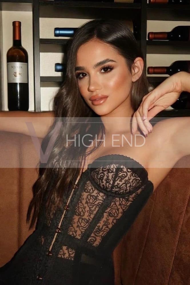 Stunning companion Paisley is wearing a corset and having her wavy hair down around her face