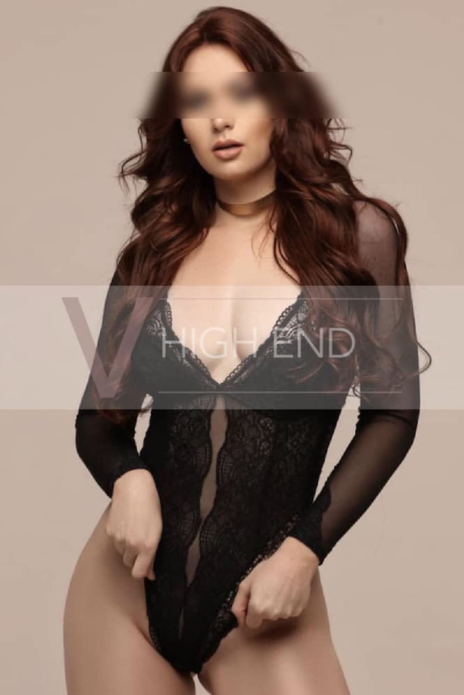 High-class companion Celina is pulling her black bodysuit down