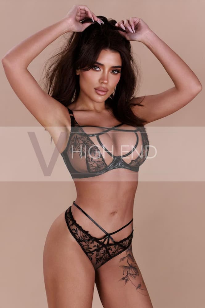 The alluring courtesan Alisha is playing with her hair, dressed in beautiful black lingerie