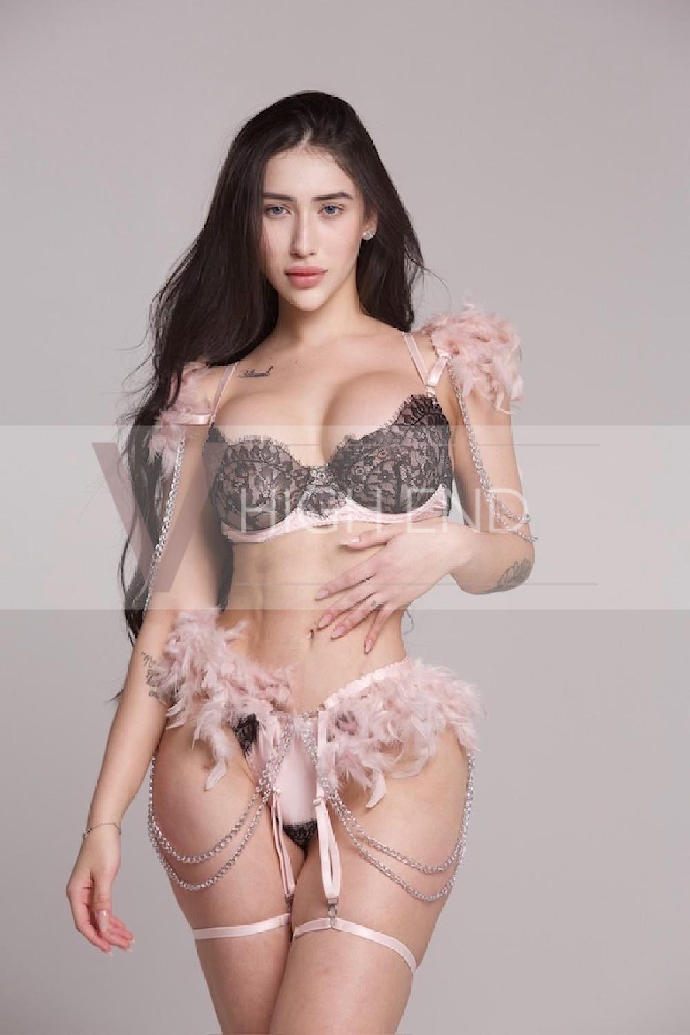 Young escort Paulina is dressed in pink furry lingerie, touching her albs while posing for the picture
